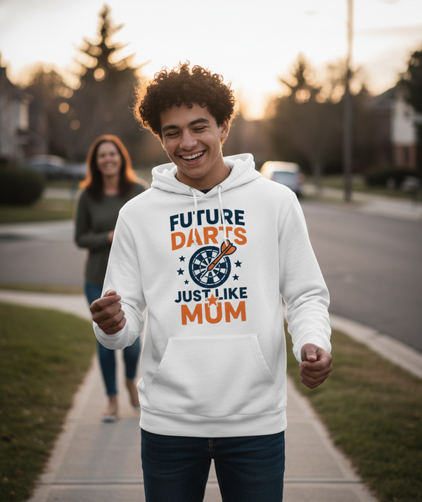 A boy wearing a Cows Corner hoodie with the funny darts slogan 'Future Darts Star Just Like Mum'. Cows Corner gifts are perfect for sport-mad fans, these gifts work brilliantly for birthdays, new baby celebrations, Father’s Day, Mother’s Day, Christmas, anniversaries, thank you gifts, end-of-season team awards, graduations, retirements, and just-because moments when you want to raise a smile. 
