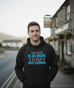 Man wearing a black hoodie with humorous text on a street background. The man is wearing a Cows Corner hoodie with the funny rugby slogan 'Your Scrum Is As Weak as Your WiFi Signal'. Cows Corner gifts are perfect for sport-mad fans, these gifts work brilliantly for birthdays, new baby celebrations, Father’s Day, Mother’s Day, Christmas, anniversaries, thank you gifts, end-of-season team awards, graduations, retirements, and just-because moments when you want to raise a smile. 

