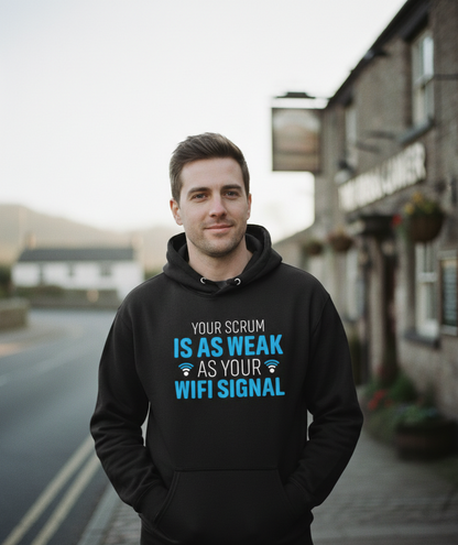 Man wearing a black hoodie with humorous text on a street background. The man is wearing a Cows Corner hoodie with the funny rugby slogan 'Your Scrum Is As Weak as Your WiFi Signal'. Cows Corner gifts are perfect for sport-mad fans, these gifts work brilliantly for birthdays, new baby celebrations, Father’s Day, Mother’s Day, Christmas, anniversaries, thank you gifts, end-of-season team awards, graduations, retirements, and just-because moments when you want to raise a smile. 
