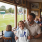 Man and young girl in a sports bar watching a game.  The girl is wearing a Cows Corner hoodie with the funny cricket slogan 'Dad Bowled Me Over With His Dad Jokes'. Cows Corner gifts are perfect for sport-mad fans, these gifts work brilliantly for birthdays, new baby celebrations, Father’s Day, Mother’s Day, Christmas, anniversaries, thank you gifts, end-of-season team awards, graduations, retirements, and just-because moments when you want to raise a smile. 
