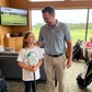 Man and young girl in a golf simulator room with a TV screen showing a golf course. The girl is wearing a Cows Corner t-shirt with the funny and sweet golf saying on the front that reads 'Dads My Coach, My Hero and the King of Lost Golf Balls'. Cows Corner gifts are perfect for sport-mad fans, these gifts work brilliantly for birthdays, new baby celebrations, Father’s Day, Mother’s Day, Christmas, anniversaries, thank you gifts, end-of-season team awards, graduations, retirements, and just-because moments