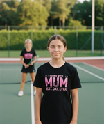 Two people on a tennis court with one wearing a black t-shirt with pink text. The girl is wearing a Cows Corner t-shirt with the funny tennis slogan 'Tennis with Mums. Best. Day. Ever!'. Cows Corner gifts are perfect for sport-mad fans, these gifts work brilliantly for birthdays, new baby celebrations, Father’s Day, Mother’s Day, Christmas, anniversaries, thank you gifts, end-of-season team awards, graduations, retirements, and just-because moments when you want to raise a smile. 
