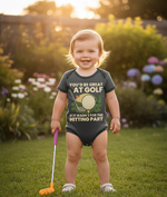 Child wearing a humorous golf-themed onesie in a garden setting. The baby is wearing a Cows Corner baby grow with a funny golf slogan 'You’d Be Great at Golf if It Wasn’t for the Hitting Part'. Cows Corner gifts are perfect for sport-mad fans, these gifts work brilliantly for birthdays, new baby celebrations, Father’s Day, Mother’s Day, Christmas, anniversaries, thank you gifts, end-of-season team awards, graduations, retirements, and just-because moments when you want to raise a smile. 
