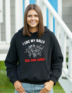 A lady wearing a black hoodie with I Like My Balls Red And Hard on the front. A Funny Cricket Hoodie, Premium Fabric, Multiple Adult Sizes