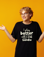 A man wearing a black t-shirt with I Play Better With A Stiff Handle on the front, A  Funny Cricket Tee, Premium Fabric, Multiple Adult Sizes