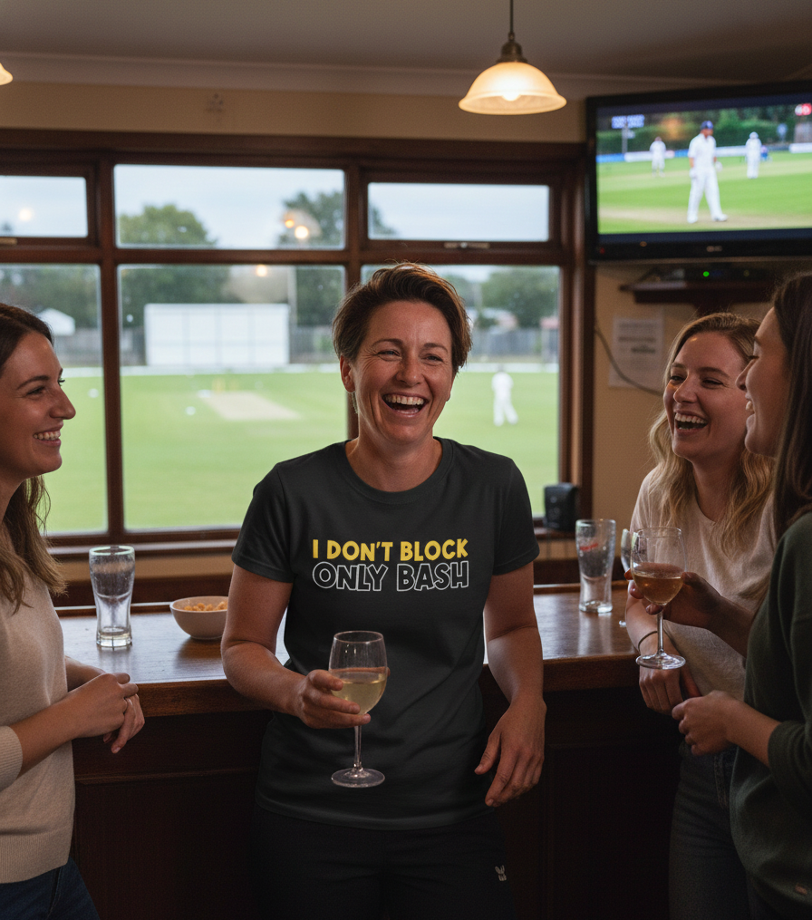 People in a pub watching cricket on TV, one person holding a glass of wine with a humorous t-shirt.  The lady is wearing a Cows Corner t-shirt with the funny cricket slogan 'I Don't Block, Only Bash' on the front.