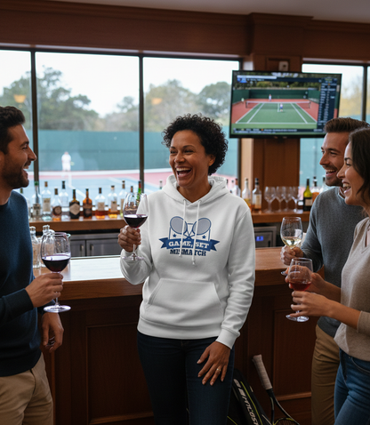 Group of people enjoying wine and conversation in a bar with a sports TV in the background. The lady is wearing a Cows Corner hoodie with the funny tennis slogan 'Game, Set, Mismatch'. Cows Corner gifts are perfect for sport-mad fans, these gifts work brilliantly for birthdays, new baby celebrations, Father’s Day, Mother’s Day, Christmas, anniversaries, thank you gifts, end-of-season team awards, graduations, retirements, and just-because moments when you want to raise a smile. 
