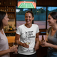 Three women in a bar with a TV showing a tennis match, one wearing a t-shirt with a tennis graphic.  The lady is wearing a Cows Corner T-shirt with the funny tennis slogan on the front that reads This Court Ain't Big Enough For Your Excuses'.  Cows Corner gifts are perfect for sport-mad fans, these gifts work brilliantly for birthdays, new baby celebrations, Father’s Day, Mother’s Day, Christmas, anniversaries, thank you gifts, end-of-season team awards, graduations, retirements, and just-because moments.