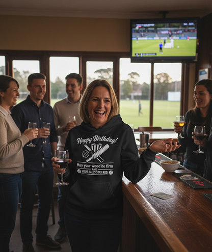 A lady wearing a Cows Corner hoodie with the funny cricket birthday slogan 'Happy Birthday! May your wood be firm and your balls stay red.'. Cows Corner gifts are perfect for sport-mad fans, these gifts work brilliantly for birthdays, new baby celebrations, Father’s Day, Mother’s Day, Christmas, anniversaries, thank you gifts, end-of-season team awards, graduations, retirements, and just-because moments when you want to raise a smile. 
