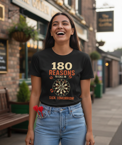Woman wearing a black t-shirt with '180 Reasons to Call in Sick Tomorrow' text, standing on a street. A Cows Corner t-shirt with the funny darts slogan '180 Reasons To Call In Sick Tomorrow'. Cows Corner gifts are perfect for sport-mad fans, these gifts work brilliantly for birthdays, new baby celebrations, Father’s Day, Mother’s Day, Christmas, anniversaries, thank you gifts, end-of-season team awards, graduations, retirements, and just-because moments when you want to raise a smile. 
