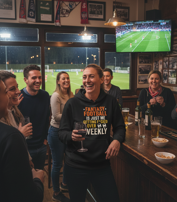 People in a bar watching sports on TV with a person holding a wine glass.  The lady is wearing a Cows Corner t-shirt with the funny fantasy football slogan on the front that reads 'Fantasy Football Is Just Me Getting F*cked Over Weekly'  Cows Corner gifts are perfect for sport-mad fans, these gifts work brilliantly for birthdays, new baby celebrations, Father’s Day, Mother’s Day, Christmas, anniversaries, thank you gifts, end-of-season team awards, graduations, retirements, and just-because moments 
