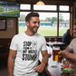Man wearing a t-shirt with a humorous cricket-related message in a pub setting.  The man is wearing a Cows Corner t-shirt with the funny cricket saying on the front that reads 'Stop Staring At My Middle Stump'