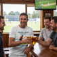 Four men in a pub watching a sports game, one holding a beer wearing a Cows Corner T-shirt with the cricket coach slogan on the front that reads 'Thanks Coach From Nets To Match Day You’ve Been There for Every Run'. Cows Corner gifts are perfect for sport-mad fans, these gifts work brilliantly for birthdays, new baby celebrations, Father’s Day, Mother’s Day, Christmas, anniversaries, thank you gifts, end-of-season team awards, graduations, retirements, and just-because moments when you want to raise a smile