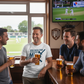 Four men in a pub watching a sports match on television, holding drinks. The man is wearing a Cows Corner t-shirt with the cricket coach slogan on the front that reads 'You Built My Technique My Confidence and My Game – Thank You'. Cows Corner gifts are perfect for sport-mad fans, these gifts work brilliantly for birthdays, new baby celebrations, Father’s Day, Mother’s Day, Christmas, anniversaries, thank you gifts, end-of-season team awards, graduations, retirements, and just-because moments 