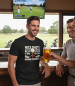 Man wearing a black t-shirt with a humorous golf-themed design, holding a beer, in a bar setting with a TV showing a golf game. The man is wearing a Cows Corner t-shirt with the funny golf slogan on the front that reads 'Nice Shot! Too Bad It Was on the Wrong Fairway'. Cows Corner gifts are perfect for sport-mad fans, these gifts work brilliantly for birthdays, new baby celebrations, Father’s Day, Mother’s Day, Christmas, anniversaries, thank you gifts, end-of-season team awards, graduations, retirements