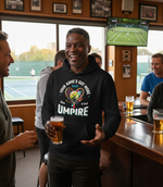 Man in a bar wearing a hoodie with a humorous message, holding a beer. The man is wearing a Cows Corner hoodie with the funny tennis slogan 'Your Game's Got More Faults Than A Bad Umpire'. Cows Corner gifts are perfect for sport-mad fans, these gifts work brilliantly for birthdays, new baby celebrations, Father’s Day, Mother’s Day, Christmas, anniversaries, thank you gifts, end-of-season team awards, graduations, retirements, and just-because moments when you want to raise a smile. 
