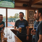 Men in a bar watching tennis on TV and drinking beer, the man is wearing a Cows Corner T-shirt with a funny tennis slogan on the front that reads 'Game, Set, Mismatch'. Cows Corner gifts are perfect for sport-mad fans, these gifts work brilliantly for birthdays, new baby celebrations, Father’s Day, Mother’s Day, Christmas, anniversaries, thank you gifts, end-of-season team awards, graduations, retirements, and just-because moments when you want to raise a smile. 
