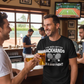 Two men in a bar with one wearing a black t-shirt with a humorous tennis graphic and text.  The man is wearing a Cows Corner T-shirt with the funny tennis slogan on the front that reads 'I've Seen Better Backhands In A Bar Fight'. Cows Corner gifts are perfect for sport-mad fans, these gifts work brilliantly for birthdays, new baby celebrations, Father’s Day, Mother’s Day, Christmas, anniversaries, thank you gifts, end-of-season team awards, graduations, retirements, and just-because moments