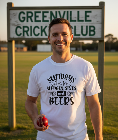 Man wearing a white t-shirt with a cricket-themed message, holding a red ball, and wearing a Cows Corner t-shirt with the funny cricket slogan 'Sundays Are for Sledges, Sixes & Beers'. Cows Corner gifts are perfect for sport-mad fans, these gifts work brilliantly for birthdays, new baby celebrations, Father’s Day, Mother’s Day, Christmas, anniversaries, thank you gifts, end-of-season team awards, graduations, retirements, and just-because moments when you want to raise a smile. 
