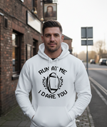 Man wearing a white hoodie with text and graphic design on a street. The man is wearing a Cows Corner hoodie with a funny rugby slogan 'Run at Me I Dare You'.  Cows Corner gifts are perfect for sport-mad fans, these gifts work brilliantly for birthdays, new baby celebrations, Father’s Day, Mother’s Day, Christmas, anniversaries, thank you gifts, end-of-season team awards, graduations, retirements, and just-because moments when you want to raise a smile. 
