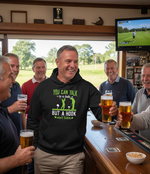 Group of men in a pub with one wearing a hoodie with humorous text, holding beer glasses. The man is wearing a Cows Corner hoodie with a funny golf slogan 'You Can Talk to a Fade but a Hook Won’t Listen'. Cows Corner gifts are perfect for sport-mad fans, these gifts work brilliantly for birthdays, new baby celebrations, Father’s Day, Mother’s Day, Christmas, anniversaries, thank you gifts, end-of-season team awards, graduations, retirements, and just-because moments when you want to raise a smile. 
