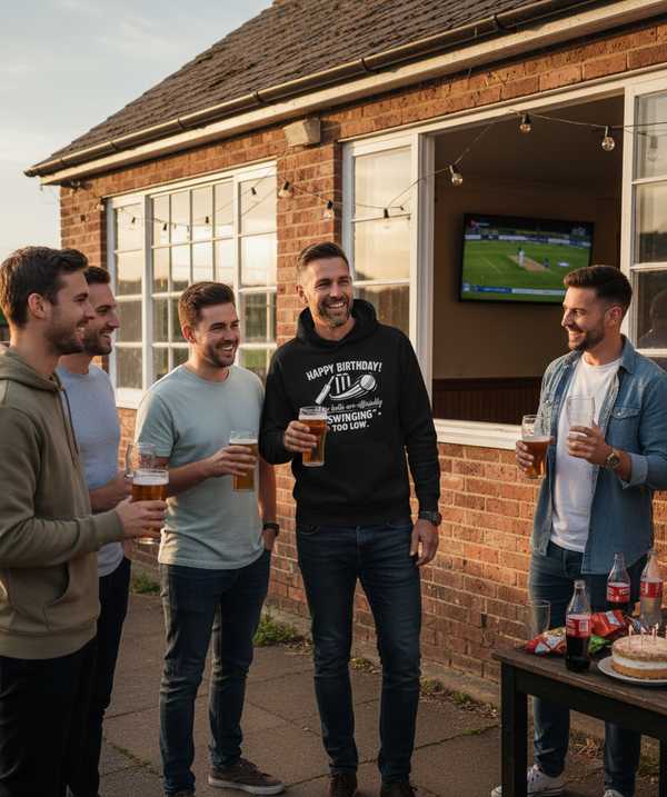 Group of men standing outside a building, holding drinks and smiling. The man is wearing a Cows Corner hoodie with the funny birthday message that reads 'Happy Birthday! Your balls are officially 'swinging' too low.' Cows Corner gifts are perfect for sport-mad fans, these gifts work brilliantly for birthdays, new baby celebrations, Father’s Day, Mother’s Day, Christmas, anniversaries, thank you gifts, end-of-season team awards, graduations, retirements, and just-because moments when you want to raise a smil