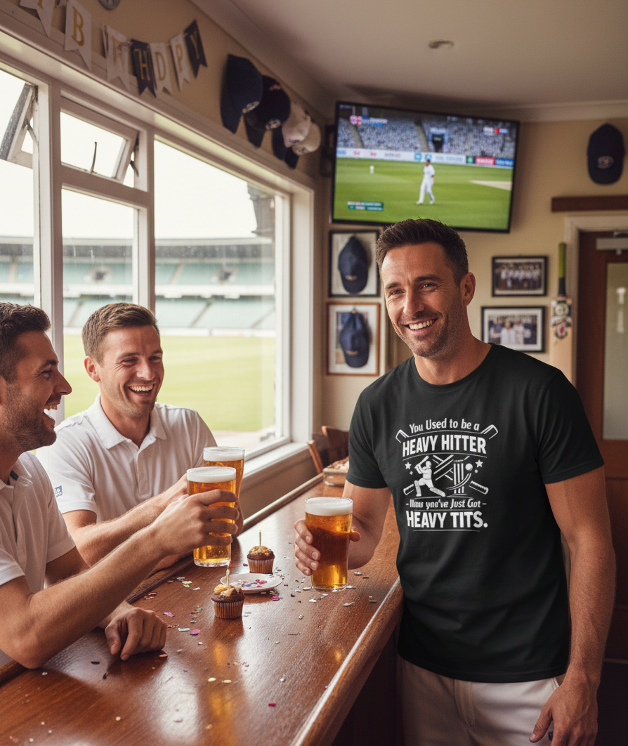 Three men in a pub watching a sports game on TV, one wearing a humorous t-shirt. A man wearing a Cows Corner t-shirt with the funny cricket birthday slogan 'You Used to be a Heavy Hitter. Now you’ve Just Got Heavy Tits.' Cows Corner gifts are perfect for sport-mad fans, these gifts work brilliantly for birthdays, new baby celebrations, Father’s Day, Mother’s Day, Christmas, anniversaries, thank you gifts, end-of-season team awards, graduations, retirements, and just-because moments 
