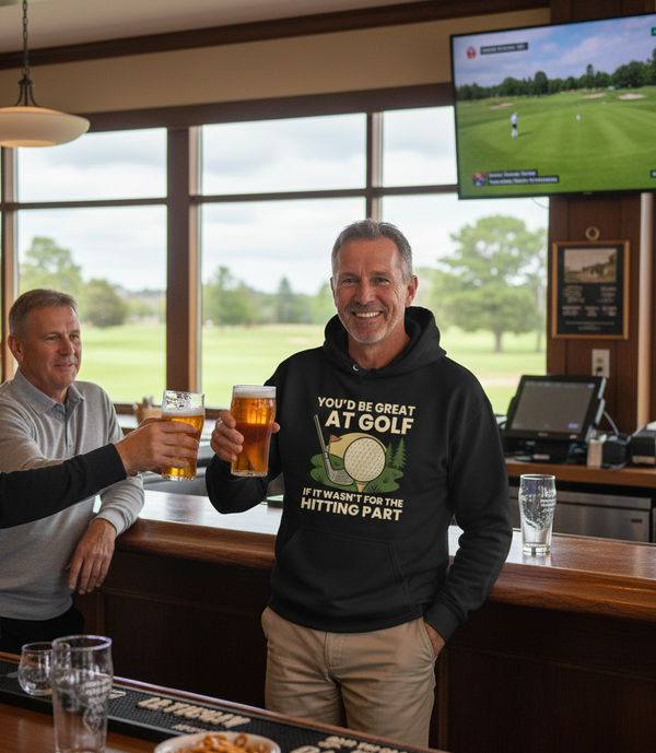 Two men in a bar with a TV showing a golf game, one wearing a hoodie with a humorous golf quote. The man is wearing a Cows Corner hoodie with the funny golf slogan 'You’d Be Great at Golf if It Wasn’t for the Hitting Part'. Cows Corner gifts are perfect for sport-mad fans, these gifts work brilliantly for birthdays, new baby celebrations, Father’s Day, Mother’s Day, Christmas, anniversaries, thank you gifts, end-of-season team awards, graduations, retirements, and just-because moments when you want to raise