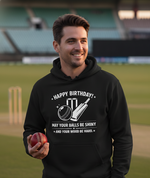 Man wearing a black hoodie with a birthday message on a cricket field. The man is wearing a Cows Corner hoodie with the funny cricket slogan 'Happy Birthday! May Your Balls Be Shiny and Your Wood Be Hard.'  Cows Corner gifts are perfect for sport-mad fans, these gifts work brilliantly for birthdays, new baby celebrations, Father’s Day, Mother’s Day, Christmas, anniversaries, thank you gifts, end-of-season team awards, graduations, retirements, and just-because moments when you want to raise a smile. 
