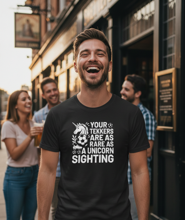 Man wearing a black t-shirt with humorous text in an urban setting. The man is wearing a Cows Corner t-shirt with the funny football slogan Your Tekkers Are As Rare as a Unicorn Sighting'. Cows Corner gifts are perfect for sport-mad fans, these gifts work brilliantly for birthdays, new baby celebrations, Father’s Day, Mother’s Day, Christmas, anniversaries, thank you gifts, end-of-season team awards, graduations, retirements, and just-because moments when you want to raise a smile. 

