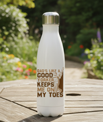 White water bottle with brown text on a wooden surface with a garden background. This is a Cows Corne water bottle with a funny cricket slogan 'Dads Like A Good Yorker, Keeps Me On My Toes'. Cows Corner gifts are perfect for sport-mad fans, these gifts work brilliantly for birthdays, new baby celebrations, Father’s Day, Mother’s Day, Christmas, anniversaries, thank you gifts, end-of-season team awards, graduations, retirements, and just-because moments when you want to raise a smile. 
