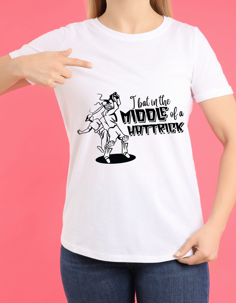 A lady wearing a white t-shirt with "I Bat In The Middle Of A Hattrick" A Funny Cricket T-shirt, Premium Fabric, Multiple Adult Sizes