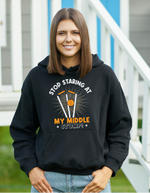 A lady wearing a black hoodie with Stop Looking at My Middle Stump on the front. A Funny Cricket Hoodie, Premium Fabric, Multiple Adult Sizes