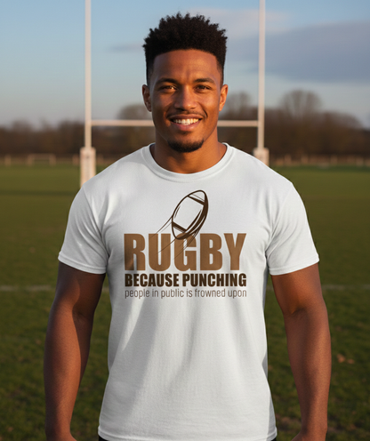 Man wearing a white t-shirt with rugby-themed text on a sports field. The man is wearing a Cows Corner t-shirt with the funny rugby slogan 'Rugby Because Punching People in Public Is Frowned Upon'. Cows Corner gifts are perfect for sport-mad fans, these gifts work brilliantly for birthdays, new baby celebrations, Father’s Day, Mother’s Day, Christmas, anniversaries, thank you gifts, end-of-season team awards, graduations, retirements, and just-because moments when you want to raise a smile. 
