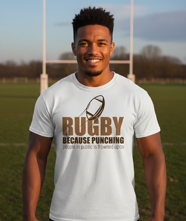 Man wearing a white t-shirt with rugby-themed text on a sports field. The man is wearing a Cows Corner t-shirt with the funny rugby slogan 'Rugby Because Punching People in Public Is Frowned Upon'. Cows Corner gifts are perfect for sport-mad fans, these gifts work brilliantly for birthdays, new baby celebrations, Father’s Day, Mother’s Day, Christmas, anniversaries, thank you gifts, end-of-season team awards, graduations, retirements, and just-because moments when you want to raise a smile. 
