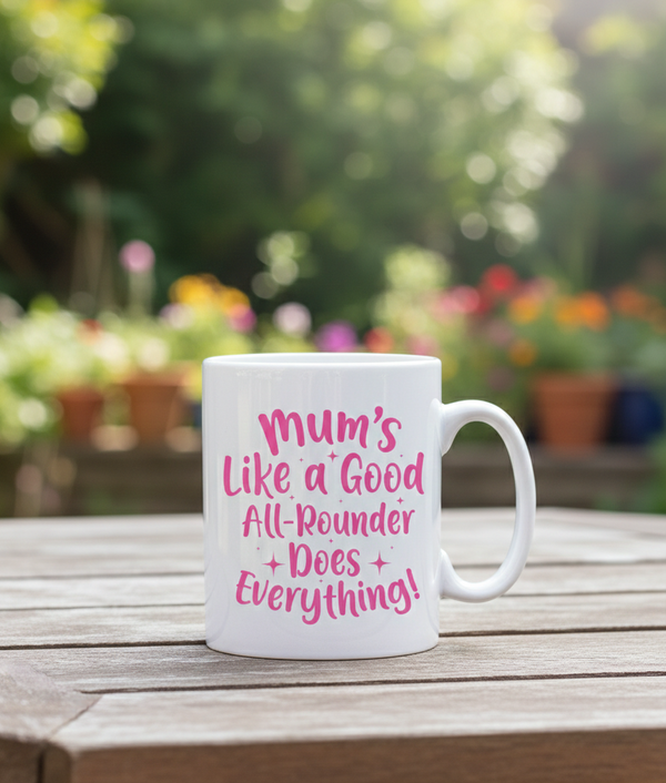 White mug with pink text on a wooden table with a garden background. This is a Cows Corner mug with a funny tennis slogan 'Mums Like A Good All-rounder, Does Everything'. Cows Corner gifts are perfect for sport-mad fans, these gifts work brilliantly for birthdays, new baby celebrations, Father’s Day, Mother’s Day, Christmas, anniversaries, thank you gifts, end-of-season team awards, graduations, retirements, and just-because moments when you want to raise a smile. 
