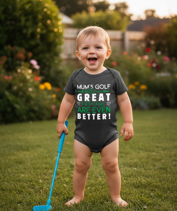 Child wearing a humorous onesie with text outdoors. The baby is wearing a Cows Corner baby grow with the funny golf slogan 'Mums Golf Skills Are Great but Her Hugs Are Even Better '. Cows Corner gifts are perfect for sport-mad fans, these gifts work brilliantly for birthdays, new baby celebrations, Father’s Day, Mother’s Day, Christmas, anniversaries, thank you gifts, end-of-season team awards, graduations, retirements, and just-because moments when you want to raise a smile. 
