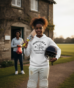 Person in white hoodie holding cricket equipment outdoors with another person in the background. The girl is wearing a Cows Corner hoodie with a funny cricket slogan 'Mums Like A Good Bat Grip, Always Holding Things Together'. Cows Corner gifts are perfect for sport-mad fans, these gifts work brilliantly for birthdays, new baby celebrations, Father’s Day, Mother’s Day, Christmas, anniversaries, thank you gifts, end-of-season team awards, graduations, retirements, and just-because moments 