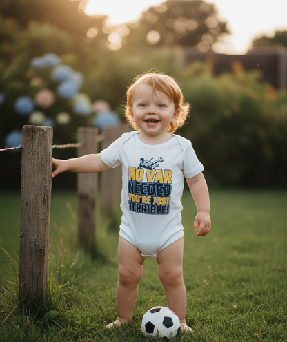 Child in a garden wearing a onesie with text, standing next to a soccer ball. The baby is wearing a Cows Corner baby grow with the funny football slogan 'No VAR Needed You’re Just Terrible'. Cows Corner gifts are perfect for sport-mad fans, these gifts work brilliantly for birthdays, new baby celebrations, Father’s Day, Mother’s Day, Christmas, anniversaries, thank you gifts, end-of-season team awards, graduations, retirements, and just-because moments when you want to raise a smile. 
