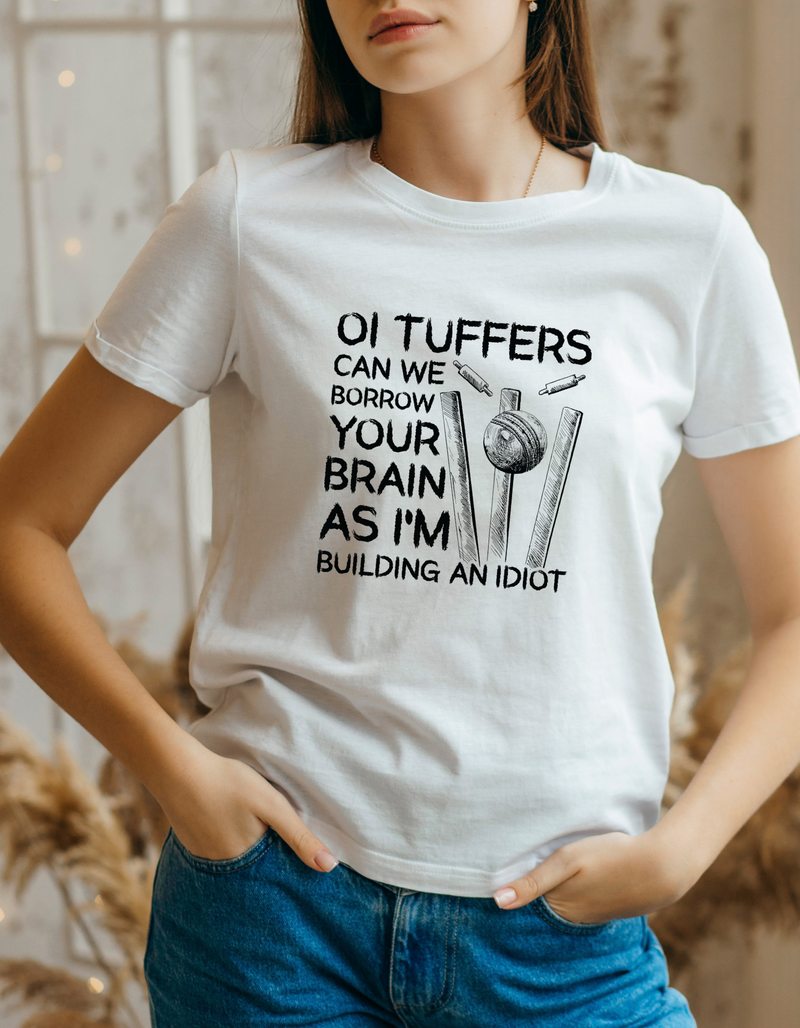 A lady wearing a white t-shirt with Oi Tuffers, Can We Borrow Your Brain on the front. A Funny Cricket T-shirt, Premium Fabric, Multiple Adult Sizes