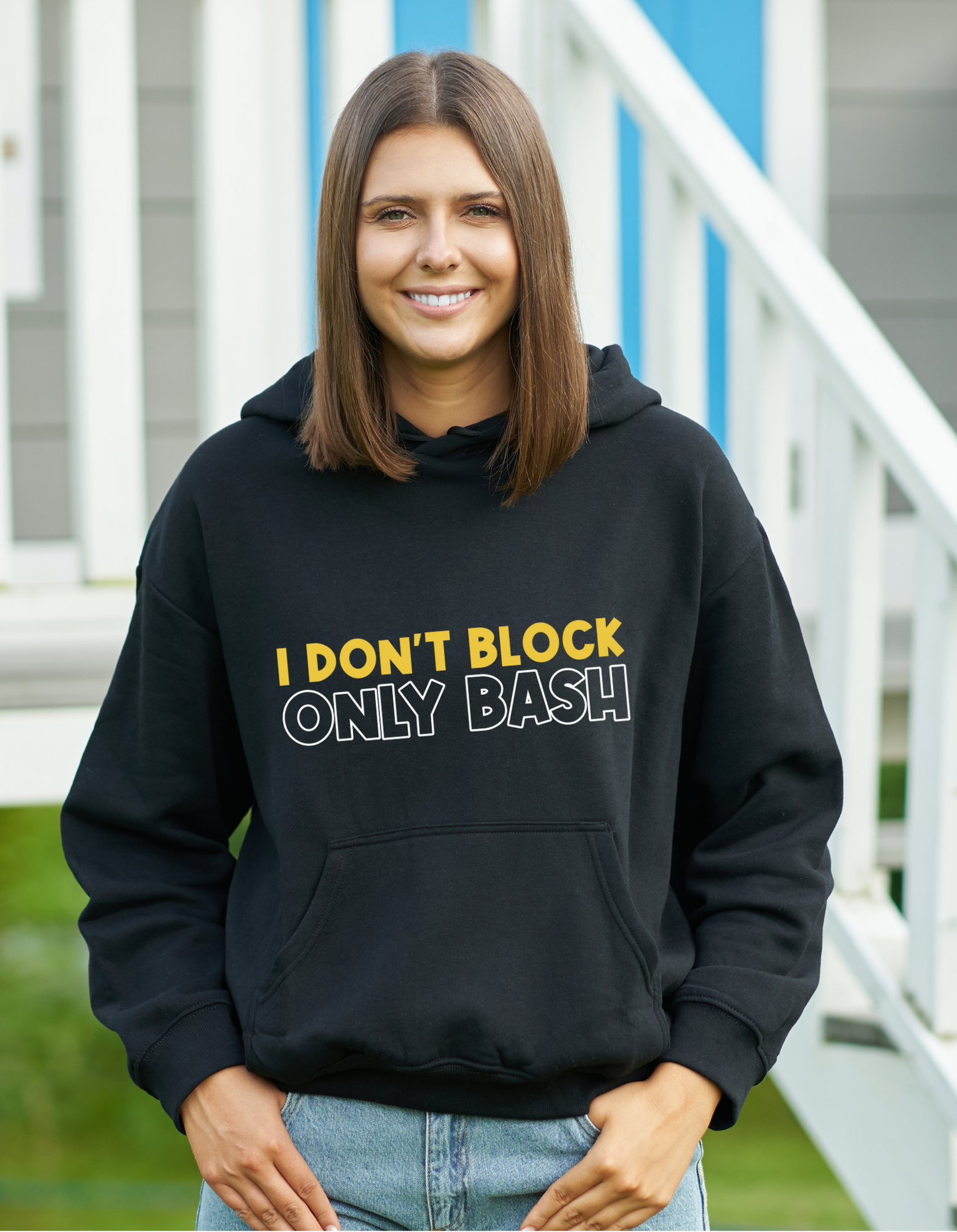 A lady wearing a black hoodie with I Don't Block Only Bash on the front!   A Funny Cricket Hoodie, Premium Fabric, Multiple Adult Sizes