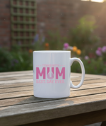 White mug with pink text on a wooden table outdoors. This is a Cows Corner mug with a funny tennis slogan 'Tennis with Mums. Best. Day. Ever!'. Cows Corner gifts are perfect for sport-mad fans, these gifts work brilliantly for birthdays, new baby celebrations, Father’s Day, Mother’s Day, Christmas, anniversaries, thank you gifts, end-of-season team awards, graduations, retirements, and just-because moments when you want to raise a smile. 
