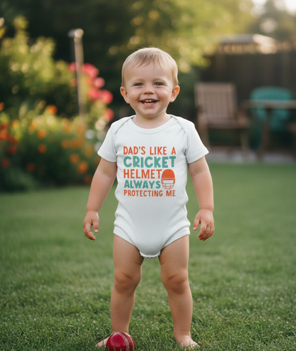 Child wearing a onesie with a humorous message outdoors on a grassy area. The baby is wearing a Cows Corner baby grow with the funny cricket slogan 'Dads like a cricket helmet always protecting me'. Cows Corner gifts are perfect for sport-mad fans, these gifts work brilliantly for birthdays, new baby celebrations, Father’s Day, Mother’s Day, Christmas, anniversaries, thank you gifts, end-of-season team awards, graduations, retirements, and just-because moments when you want to raise a smile. 

