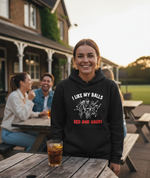 Person wearing a black hoodie with text and graphic, sitting at a table outdoors.The lady is wearing a Cows Corner hoodie with the funny cricket slogan 'I Like My Balls Red And Hard'. Cows Corner gifts are perfect for sport-mad fans, these gifts work brilliantly for birthdays, new baby celebrations, Father’s Day, Mother’s Day, Christmas, anniversaries, thank you gifts, end-of-season team awards, graduations, retirements, and just-because moments when you want to raise a smile. 
