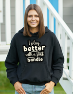 A lady wearing a black hoodie with I Play Better with a Stiff Handle, on the front. A  Funny Cricket Hoodie, Premium Fabric, Multiple Adult Sizes