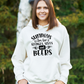 A lady wearing a white hoodie with Sundays Are for Sledges Sixes and Beers, on the front.  Funny Cricket Hoodie, Premium Fabric, Multiple Adult Sizes