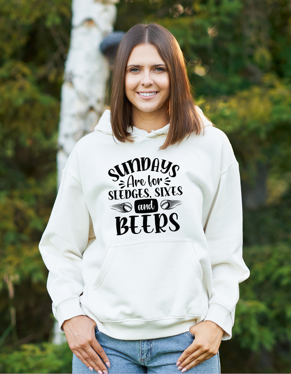 A lady wearing a white hoodie with Sundays Are for Sledges Sixes and Beers, on the front.  Funny Cricket Hoodie, Premium Fabric, Multiple Adult Sizes