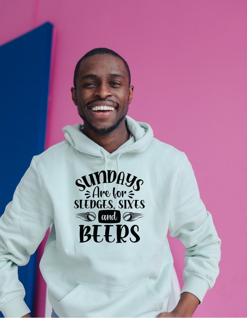 A man wearing a white hoodie with Sundays Are for Sledges Sixes and Beers, on the front.  Funny Cricket Hoodie, Premium Fabric, Multiple Adult Sizes