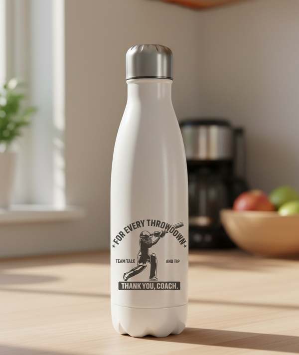 White water bottle with a printed design on a kitchen counter. This is a Cows Corner water bottle with a funny cricket slogan 'For every throwdown, team talk and tip, thank you coach'. Cows Corner gifts are perfect for sport-mad fans, these gifts work brilliantly for birthdays, new baby celebrations, Father’s Day, Mother’s Day, Christmas, anniversaries, thank you gifts, end-of-season team awards, graduations, retirements, and just-because moments when you want to raise a smile. 
