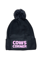 Black beanie with pink 'Cows Corner' logo on a white background
